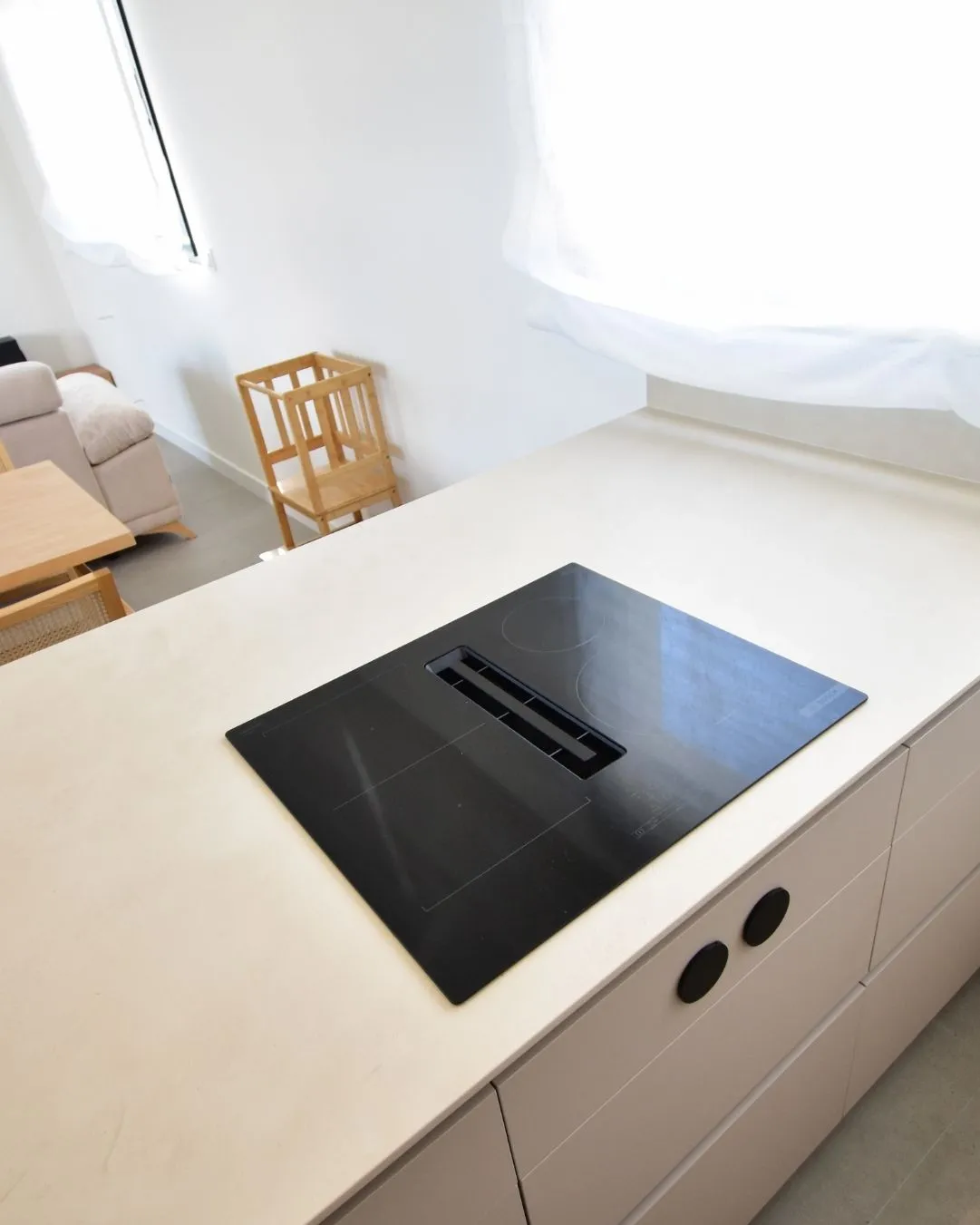 Placa de cocción con extractor integrado en cocina oculta y minimalista