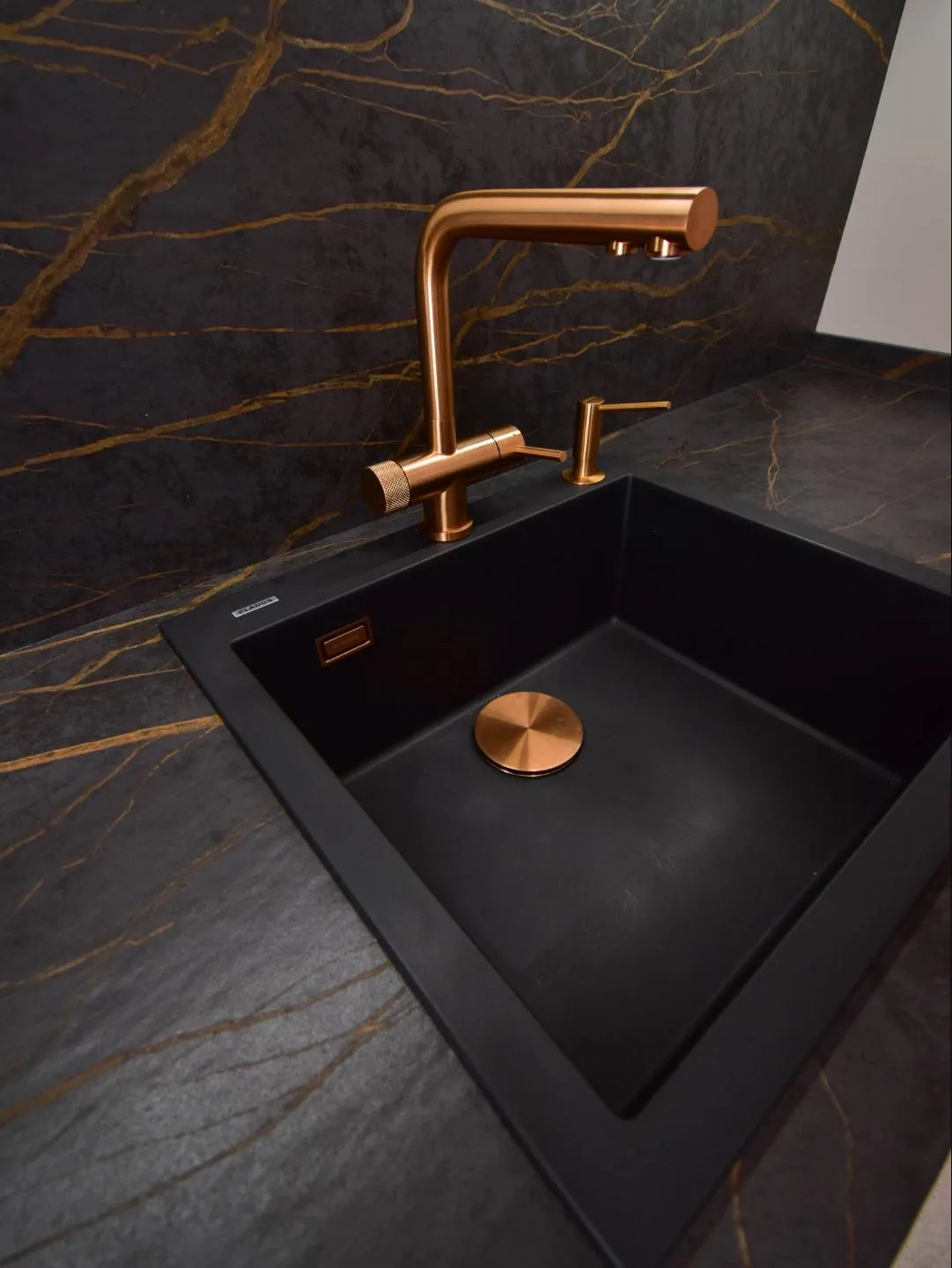 Grifo cobre en cocina con península y pared panelada