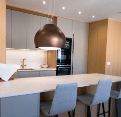 Elegante cocina abierta con placa invisible y campana decorativa