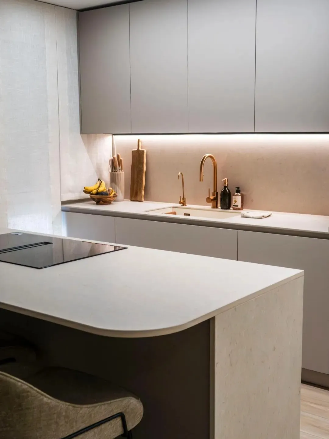 Detalle curvo en península de cocina abierta con placa con extractor integrado