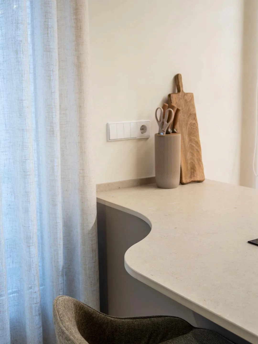 Detalle curvo en península de cocina abierta con placa con extractor integrado