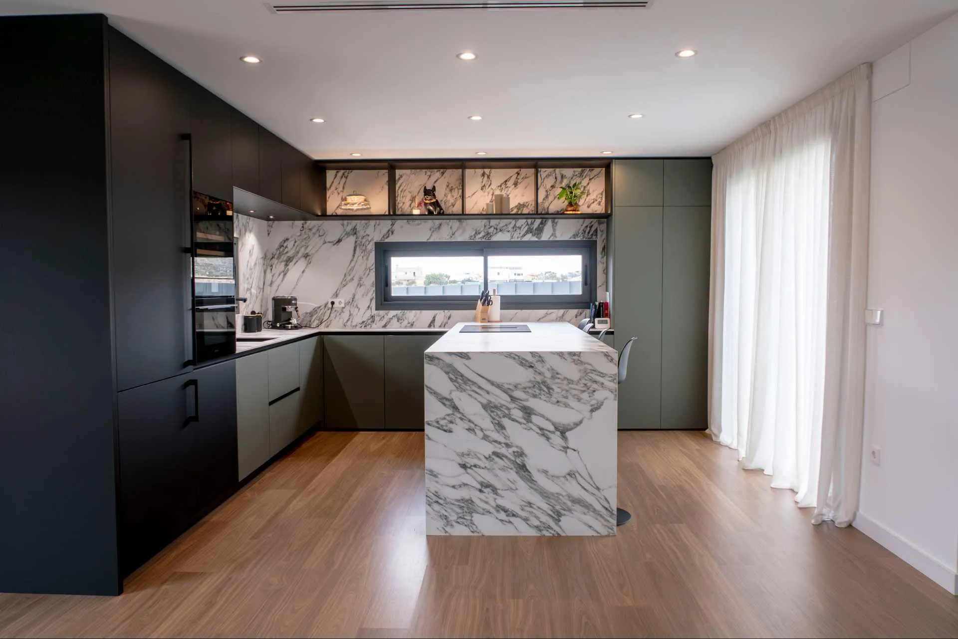 Cocina con isla en tonos oscuros y con encimera Arabescatto White