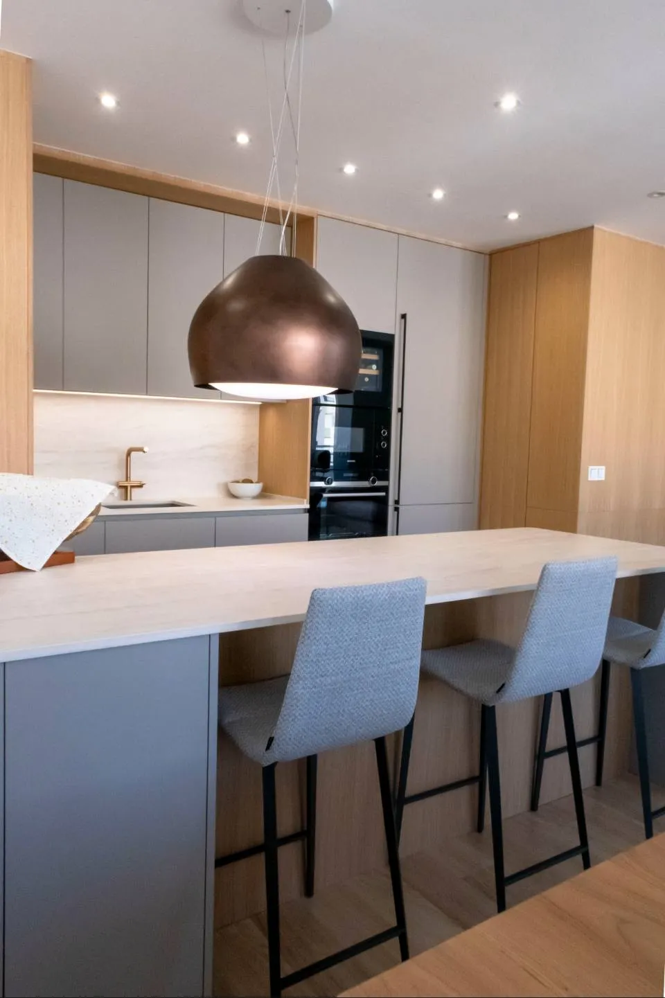 Elegante cocina con placa invisible y campana decorativa