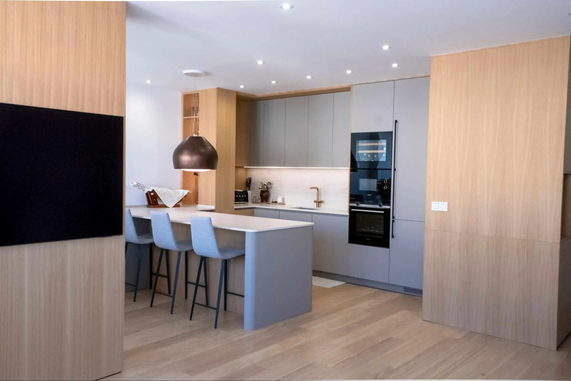 Elegante cocina con placa invisible y campana decorativa Elegante cocina con placa invisible y campana decorativa