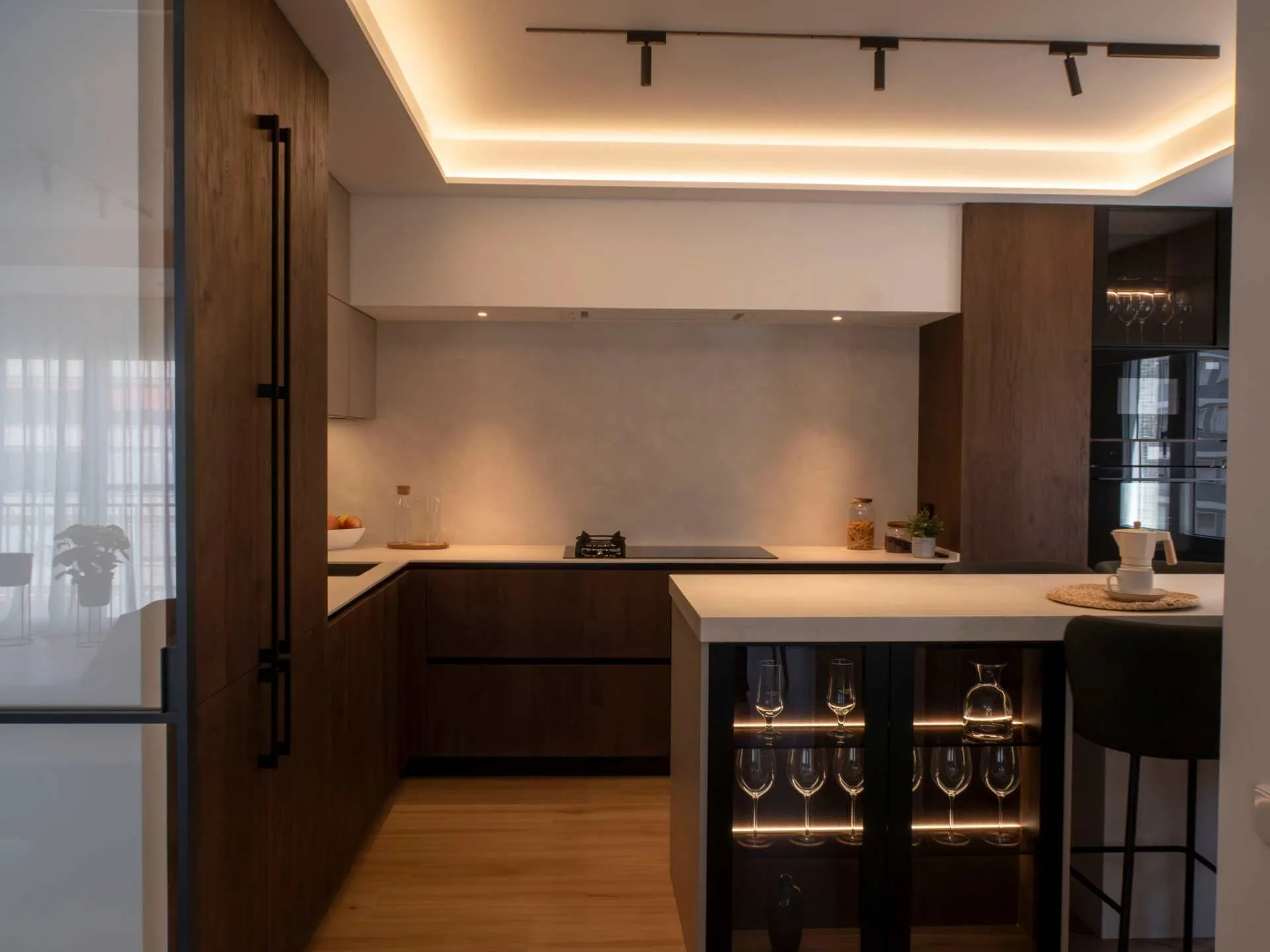 Sofisticada cocina con isla y cerramiento de cristal