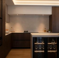 Sofisticada cocina con isla y cerramiento de cristal