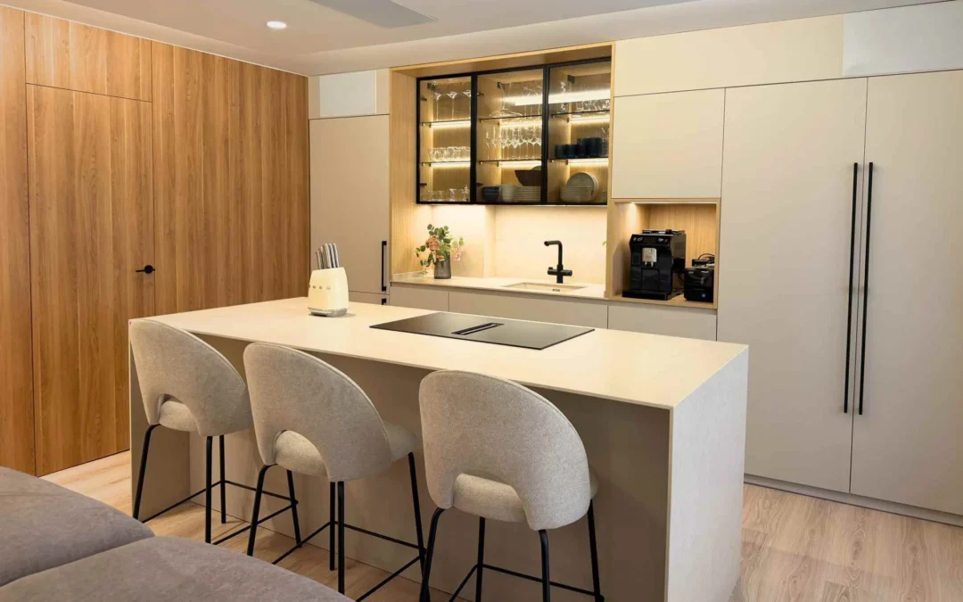 Cocina abierta al salón con amplia isla y elegantes vitrinas