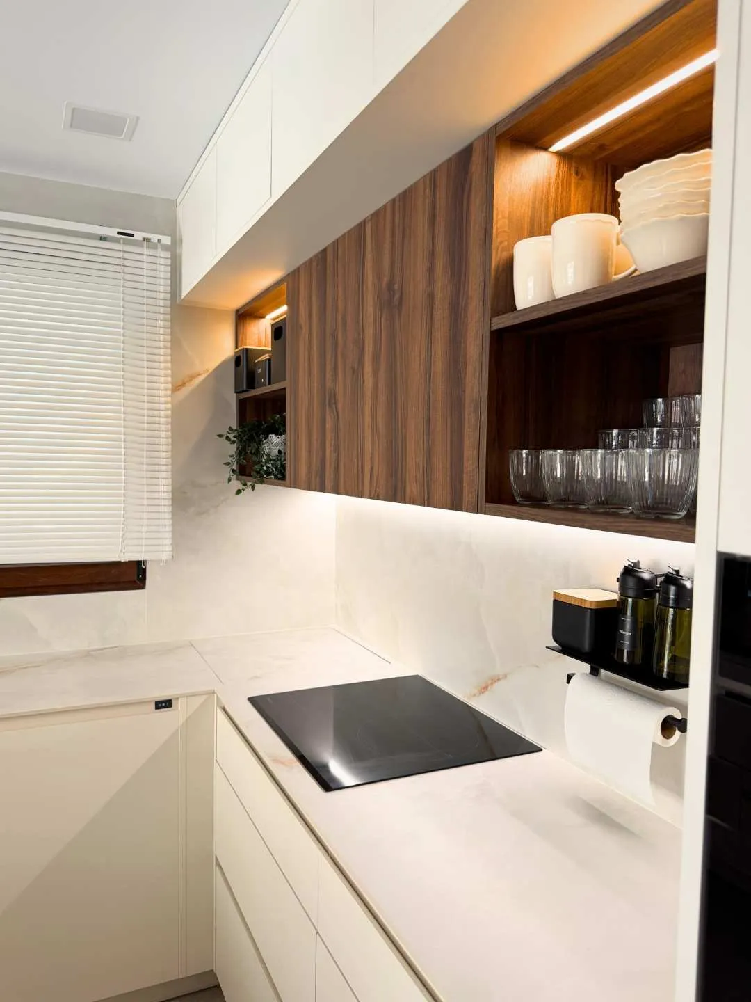 Placa de inducción en moderna cocina en blanco roto y madera roble